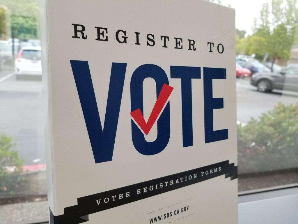 A register to vote sign outside a voter registration location