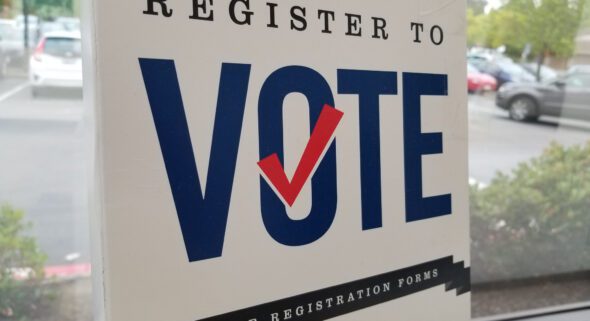 A register to vote sign outside a voter registration location