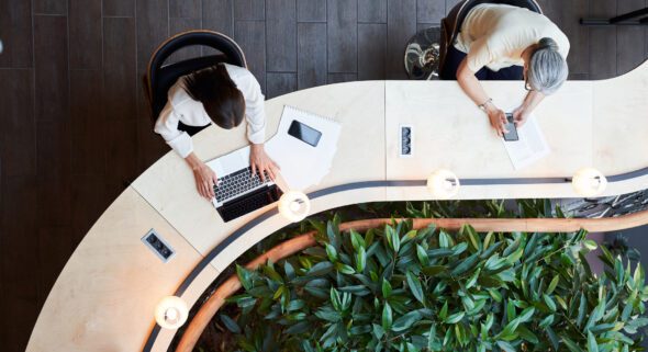 Overhead image of two people working from an office desk
