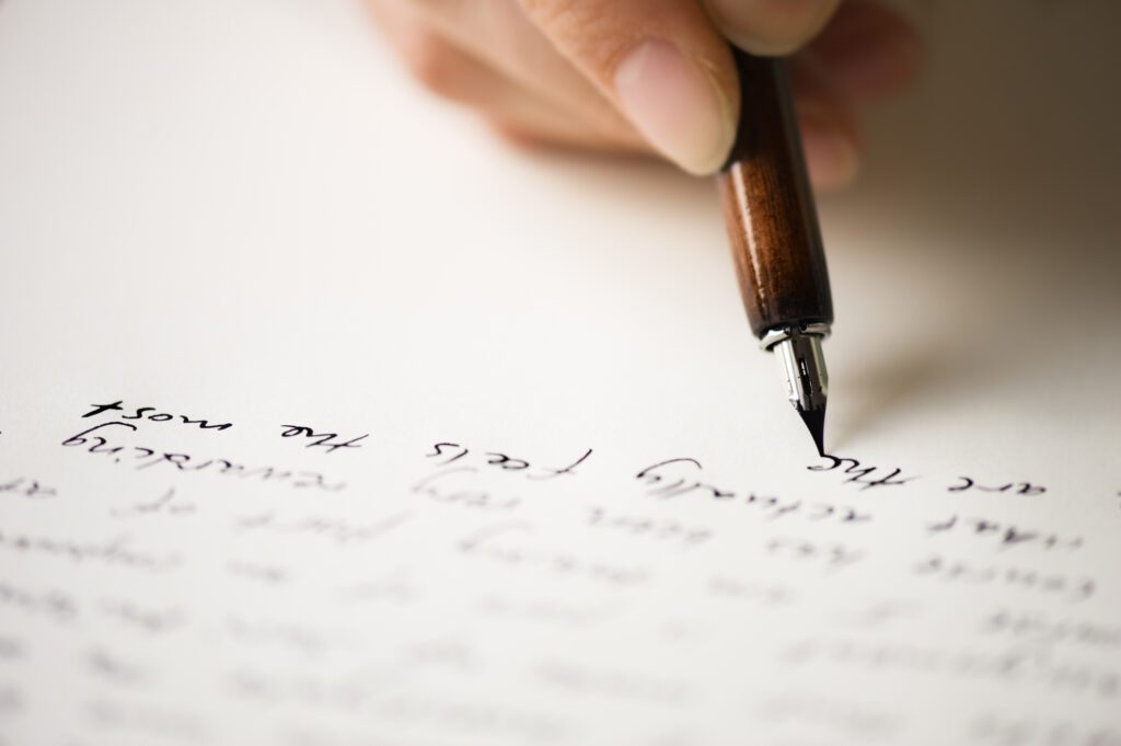 Close up of a woman hand writing a letter to a friend