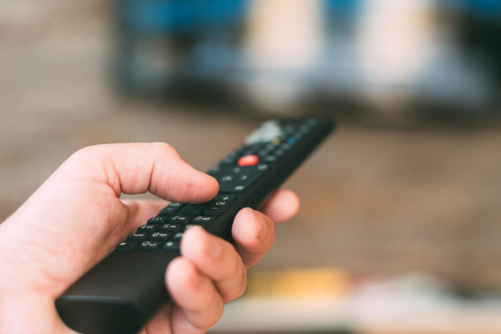 TV viewer holding television remote