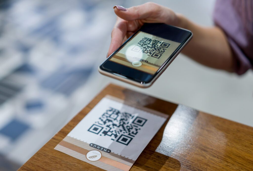 Close-up on a woman scanning a QR code at a restaurant