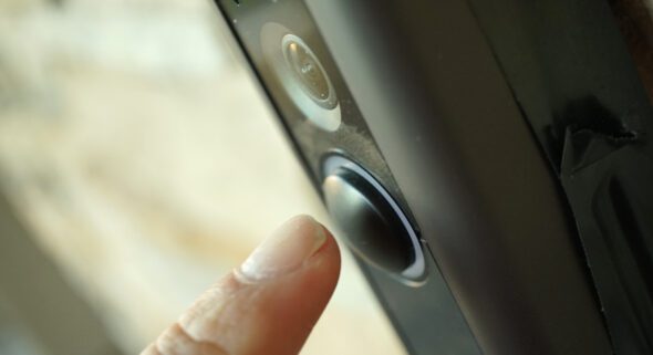 close up of a person's hand ringing a doorbell